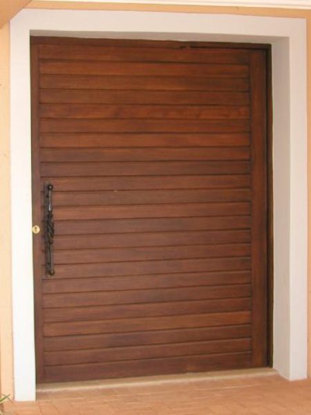 Picture of the meranti horizontal slatted pivot door installed as the front door of a house