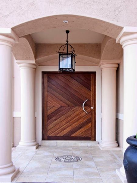 Picture of the 6 panel pivot door in an archway, closed.