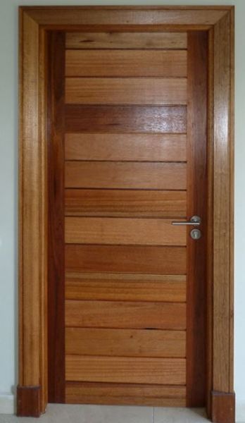 Picture of the Horizontal Slatted Meranti 813 mm x 2032 mm Exterior Door shown stained and sealed, installed in a doorway with hardware